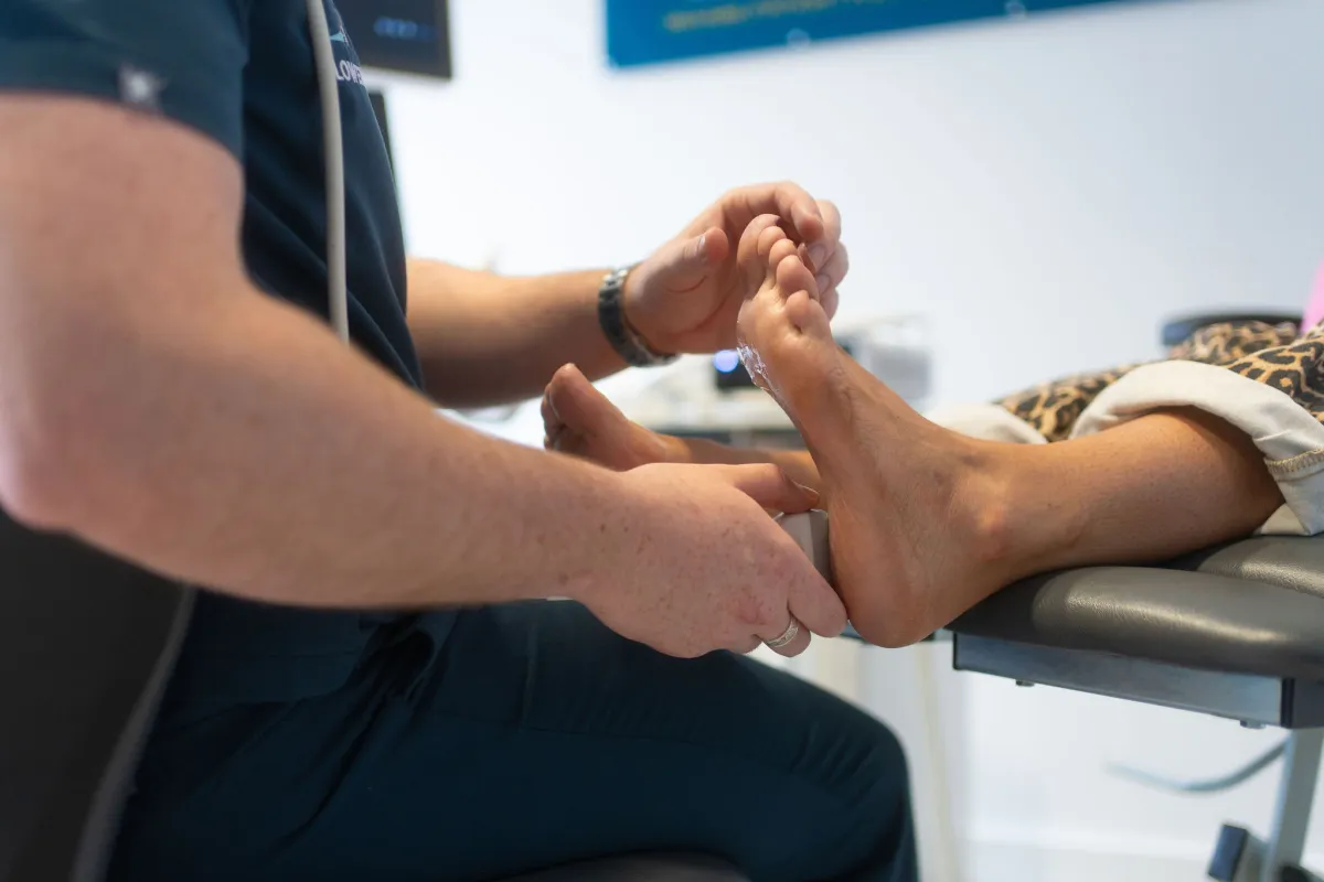 Close-up of a podiatrist examining a patient's foot during a verruca assessment at Lower Limb Clinic Belfast